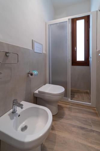 a bathroom with a toilet and a sink and a shower at Baglio Tuzza in Marsala