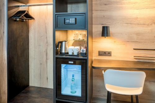 a small kitchen with a table and a drink machine at Best Western Hotel München Airport in Erding