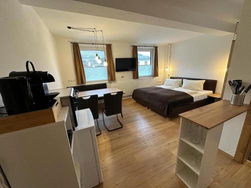 a living room with a bed and a desk with a television at Willi‘s Studio in Saalbach Hinterglemm