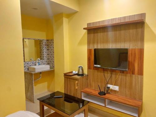 a hotel room with a television and a sink at Hotel Shobha Forbesganj in Forbesganj