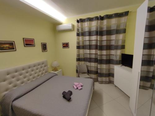 Ospitalità Baffone casa vacanze في Mercato: غرفة نوم مع سرير مع اثنين من الحيوانات المحشوة عليه