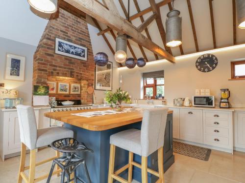 a kitchen with a large island with bar stools at The Old Byre in Salisbury
