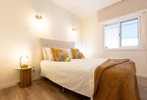 a bedroom with a large white bed with a window at BEACHOME4u 5 in Parede