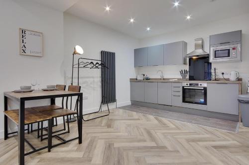 a kitchen with a table and a dining room at Ashley Road Apartment 1 in Poole