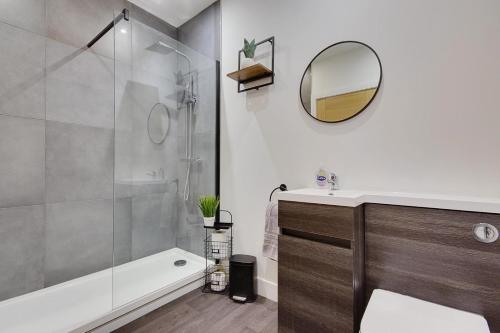 a bathroom with a shower and a sink and a mirror at Ashley Road Apartment 1 in Poole