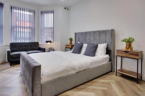 a bedroom with a large bed and a chair at Ashley Road Apartment 1 in Poole