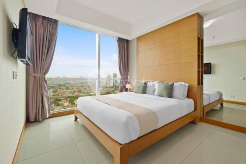 1 dormitorio con cama grande y ventana grande en Cera by Kozystay - 2BR - Mall Access - Kemang, en Yakarta