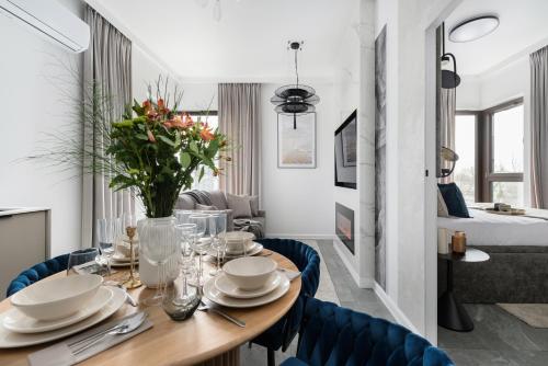 a dining room with a table and blue chairs at Sol Marina Resort Wyspa Sobieszewska II - LoftAffair Collection in Wiślinka