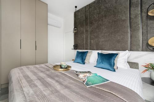 a bedroom with a large bed with blue pillows at Sol Marina Resort Wyspa Sobieszewska II - LoftAffair Collection in Wiślinka