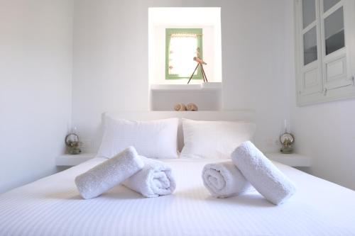 Un dormitorio con una cama blanca con toallas. en Nymph Klido, en Kanakis