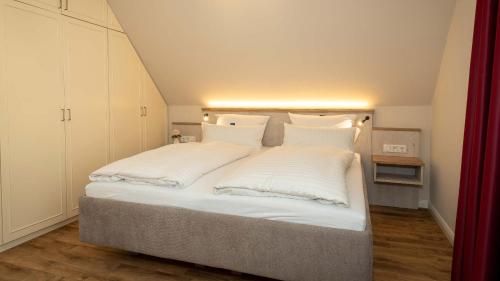 łóżko z białą pościelą i poduszkami w pokoju w obiekcie Hotel Rosengarten w mieście Hamburg