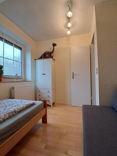a bedroom with a bed and a cat on top of a dresser at FeWo Nordsee Whng 3 in Wangerland