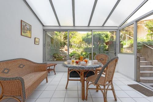 une véranda avec une table et des chaises dans l'établissement la Voûte, à Carcassonne