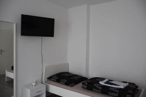 a room with a bed with a flat screen tv on the wall at Hirsch24- 6 Betten -Apartment in Lippstadt