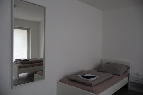 a mirror in a bedroom with a bed and a mirror at Hirsch24- 6 Betten -Apartment in Lippstadt