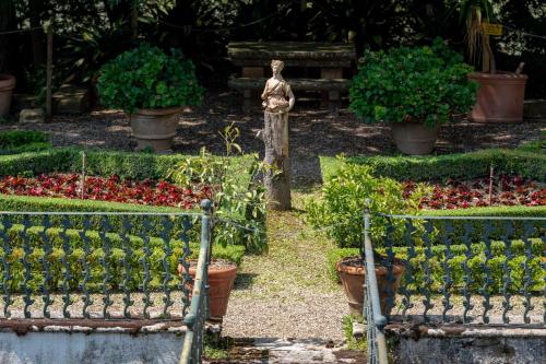 a garden with pots of plants and a statue at Certosa di Pontignano Residenza d'Epoca - Place of Charme in Ponte A Bozzone