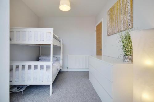 a white bedroom with a bunk bed and a ladder at Ashley Road Apartment 2 in Poole
