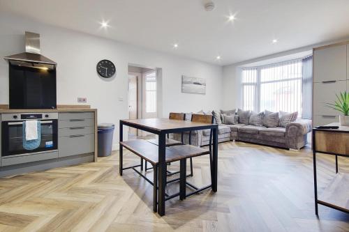 a kitchen and living room with a table and a couch at Ashley Road Apartment 2 in Poole