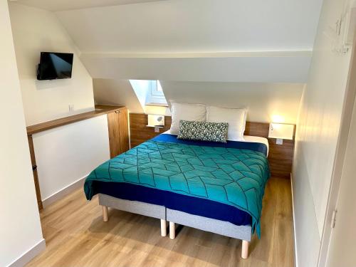 Dormitorio pequeño con cama con edredón verde en Hotel Zora, en París