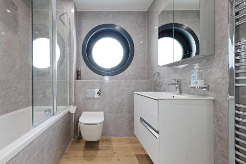 a bathroom with a toilet and a sink and a mirror at Gorgeous 2 Bed Apartment with Stunning Sea Views with Free Parking and Fast Internet in Ramsgate