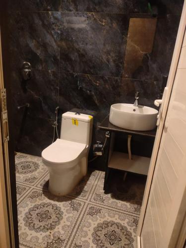 a bathroom with a toilet and a sink at The Kiana's in Mussoorie