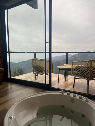 a bath tub in the middle of a room with a view at The Kiana's in Mussoorie