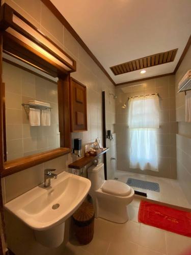 a bathroom with a white sink and a toilet at EL RIO Y MAR RESORT in Coron
