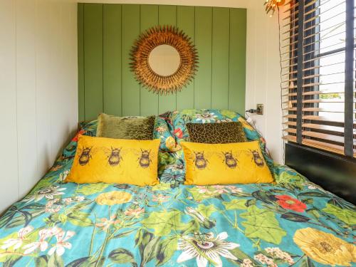 sypialnia z łóżkiem z żółtymi poduszkami i lustrem w obiekcie Portland w mieście Retford
