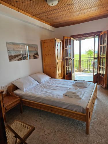 sypialnia z dużym łóżkiem i drewnianym sufitem w obiekcie OASIS BEACH HOUSE w mieście Vergia