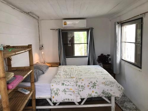 um pequeno quarto com uma cama e uma janela em The white house em Ko Phangan