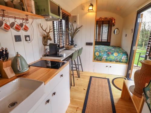 una cocina en una casa pequeña con fregadero y cama en Southdown, en Retford