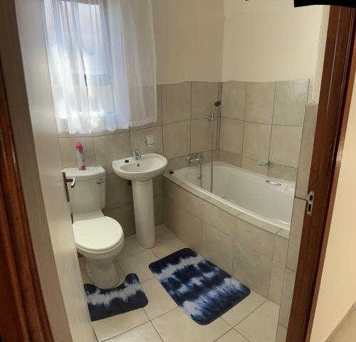 uma casa de banho com um WC, um lavatório e uma banheira em MV self-catering Linden em Bloemfontein