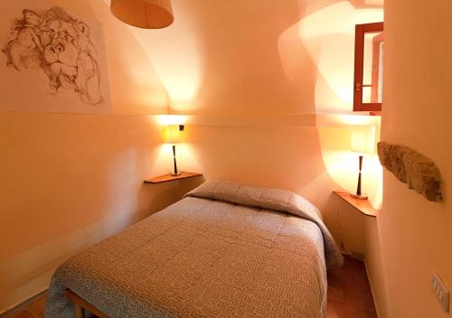 a small bedroom with a bed and two lamps at Casa in zona strategica in Spoleto