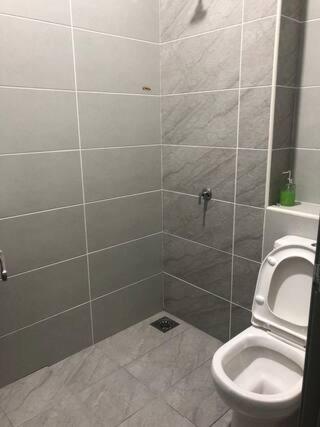 a bathroom with a toilet and a shower stall at D' HOME MERIDIAN in Kluang