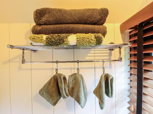 a towel rack with towels and mittens on it at Herdwick in Retford