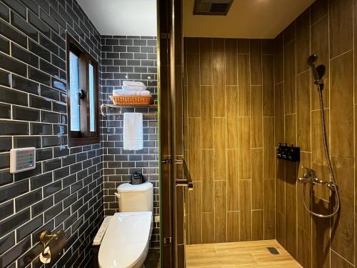 a bathroom with a toilet and a shower with tiles at 金門悠哉悠古厝民宿 Yozaiyo39 B&B in Jinning