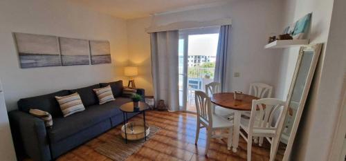 ein Wohnzimmer mit einem Sofa und einem Esstisch in der Unterkunft Apartamento 203 Castell Sol CB in Arenal d'en Castell