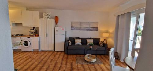a living room with a couch and a kitchen at Apartamento 203 Castell Sol CB in Arenal d'en Castell