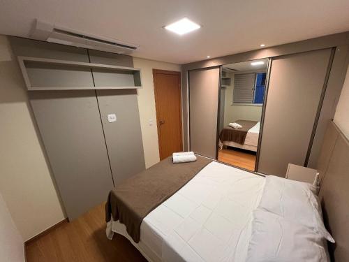 een kleine slaapkamer met een bed en een spiegel bij Locking's Savassi 09 in Belo Horizonte