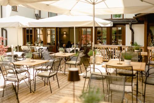 a restaurant with tables and chairs and umbrellas at Boutiquehotel Hubertushof in Bad Ischl