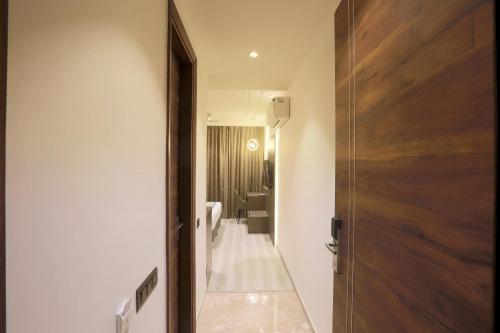 ein Bad mit WC und eine Tür zu einem Zimmer in der Unterkunft OPO Hotels D'or in Neu-Delhi