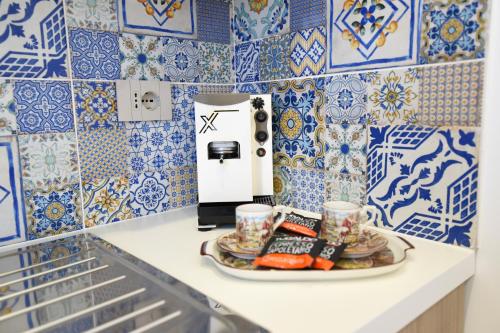 un plato de comida y tazas en un mostrador con baldosas azules en Acunto's Homes, en Agerola