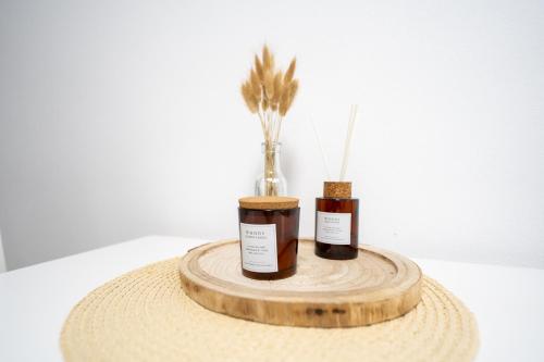 two vases on a wooden tray with feathers in it at Apartmány Gemini in Zlín