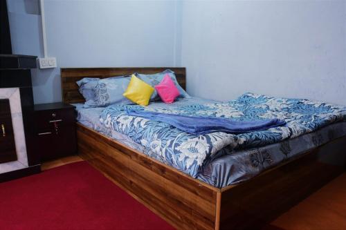 a bed with two colorful pillows on top of it at Darjeeling Homes in Darjeeling