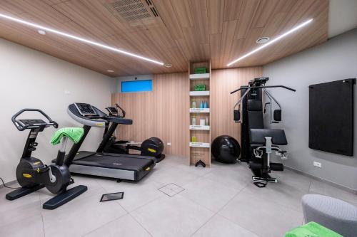 a gym with two exercise bikes and a flat screen tv at Airport Hotel Bergamo in Bagnatica