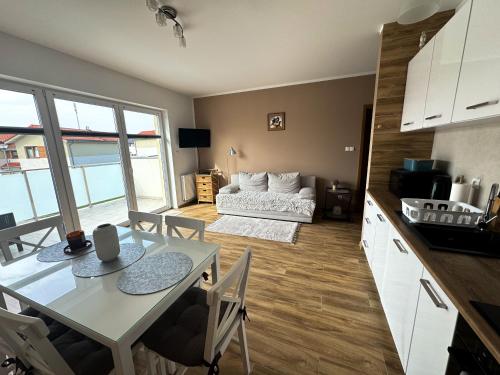 a kitchen and living room with a table and chairs at Apartament USTKA in Ustka