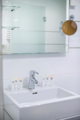 a white bathroom sink with a mirror and a sink at Spa Hotel Diana in Františkovy Lázně