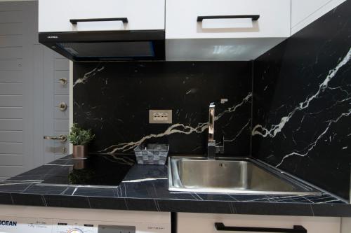 a kitchen with a sink and a black counter top at Niki’s Apartments in Tirana
