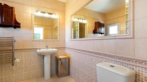 ein Badezimmer mit einem Waschbecken, einem WC und einem Spiegel in der Unterkunft Ursinho in Albufeira