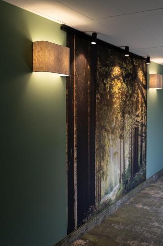 a wall with a painting on it with a light on it at Best Western Hotel München Airport in Erding